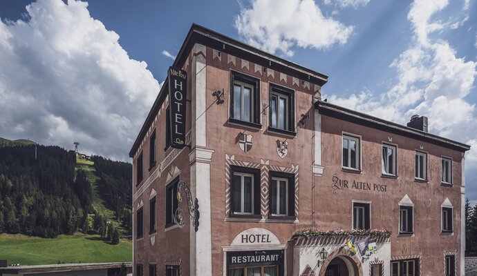 Aussenansicht eines mehrstöckigen, rötlichem Gebäude | © Davos Klosters Mountains 