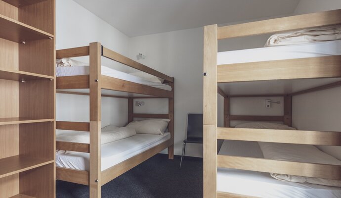 Simple room with 2 bunk beds and wardrobe | © Davos Klosters Mountains 