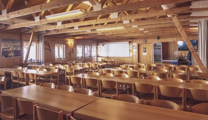 Large bright breakfast room with tables and chairs | © Davos Klosters Mountains