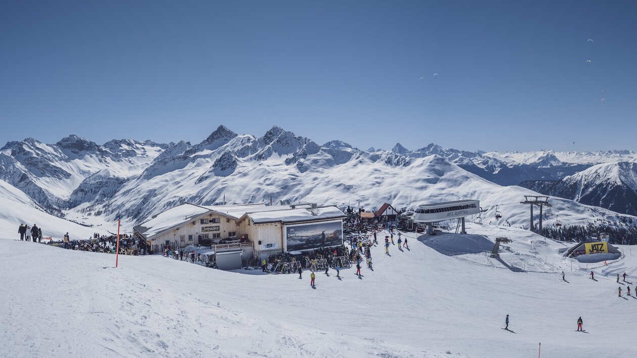 Sicht auf das Bergrestaurant Jatzhütte mit atemberaubenden Bergpanorama im Hintergrund. | © Davos Klosters Mountains