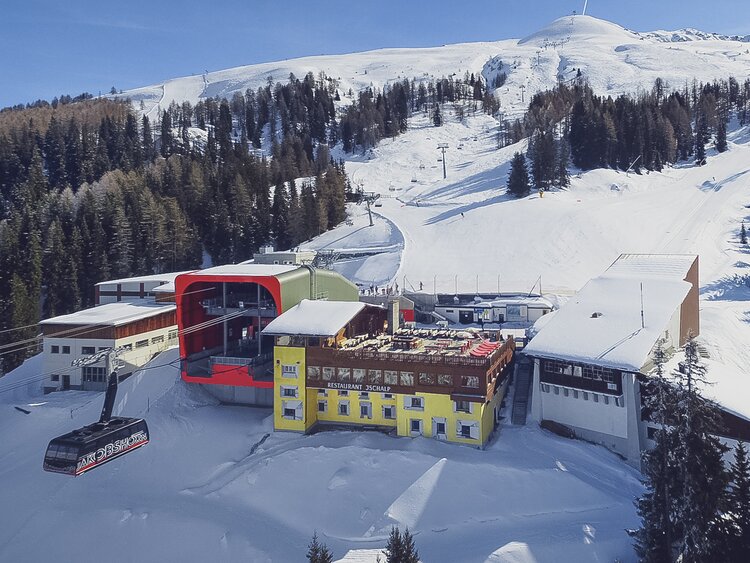 Luftaufnahme von der Bergstation und dem Berghaus Jschalp mit der Skipiste Brämabüel im Hintergrund. | © Davos Klosters Mountains
