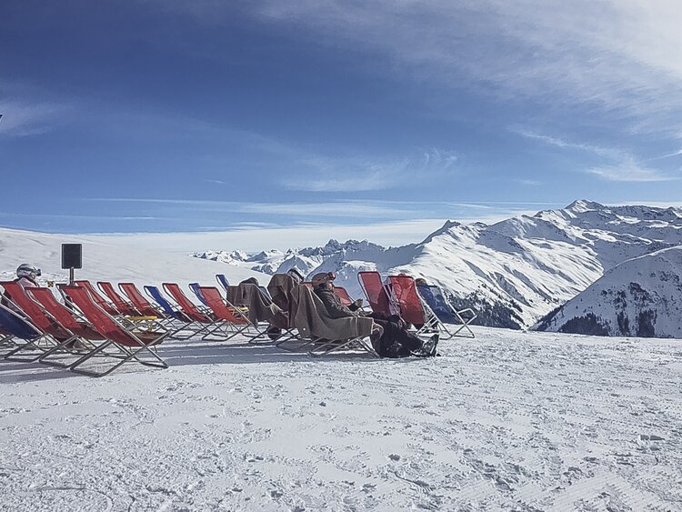 Rote Liegen stehen aufgereiht auf der Aussichtsterrasse der Gruobenalp. | © Davos Klosters Mountains