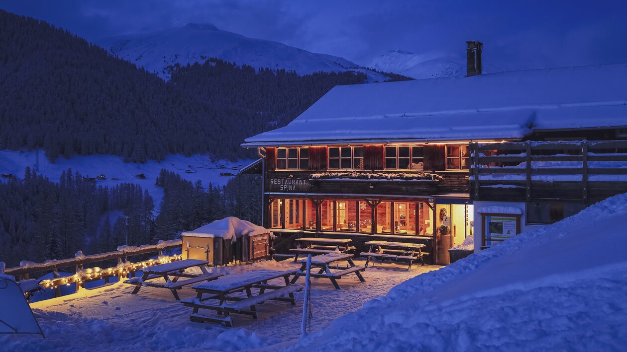 Das heimelige von innen beleuchtete Restaurant Spina in Davos. | © Davos Klosters Mountains