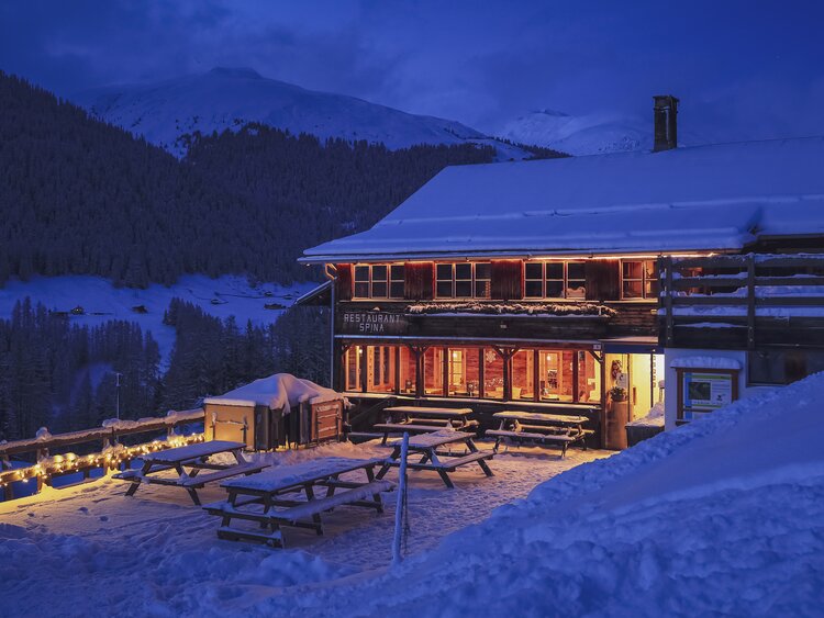 Das heimelige von innen beleuchtete Restaurant Spina in Davos. | © Davos Klosters Mountains