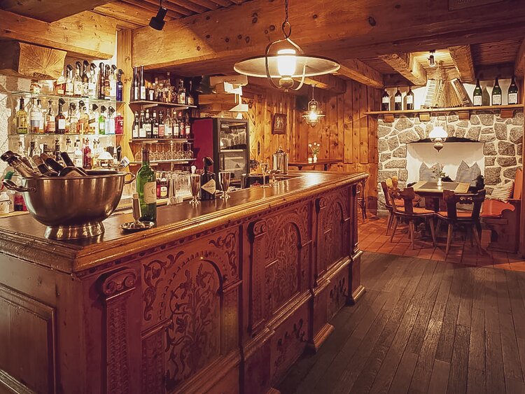 Das traditionelle Buffet mit wunderschöner Prägung im Holz bestückt mit Getränken. | © Davos Klosters Mountains