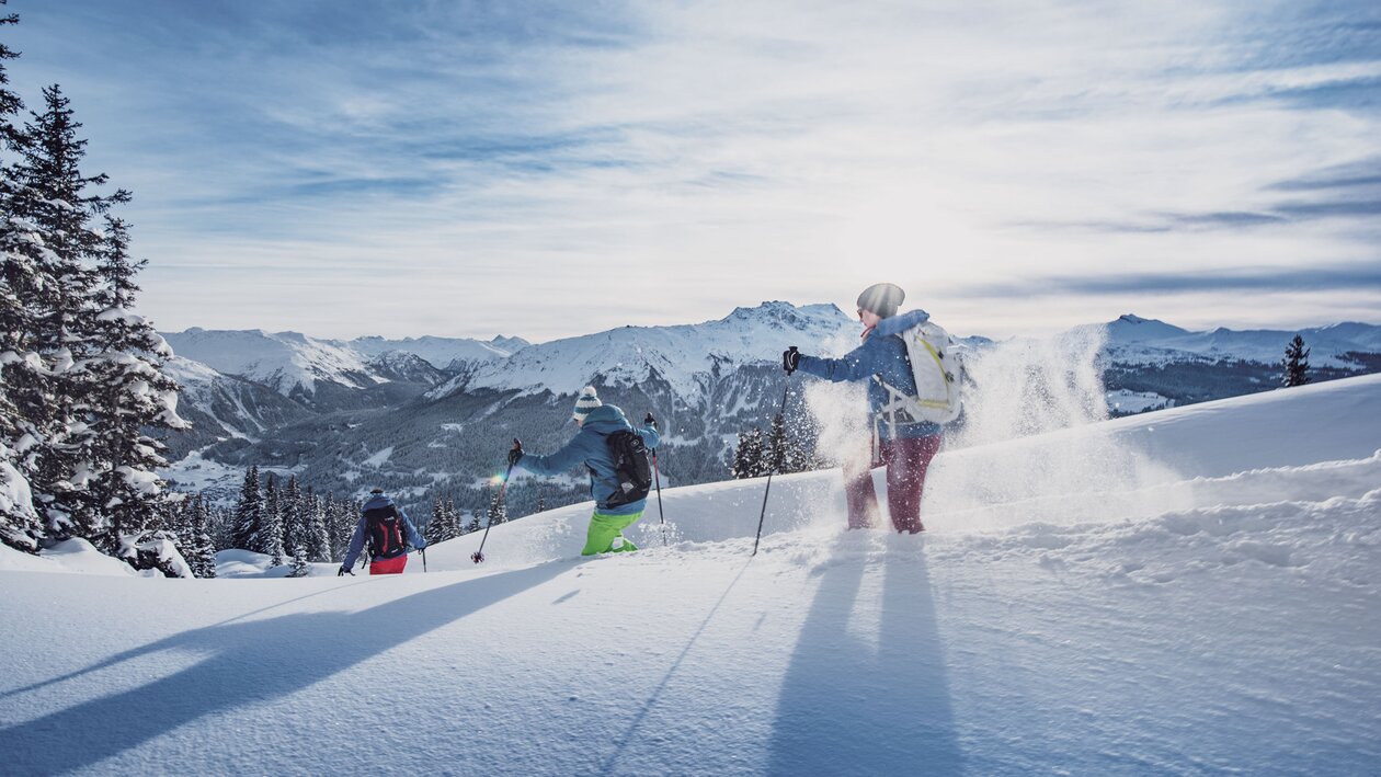 Drei Personen geniessen das Schneeschuhlaufen durch den Tiefschnee. | © Destination Davos Klosters