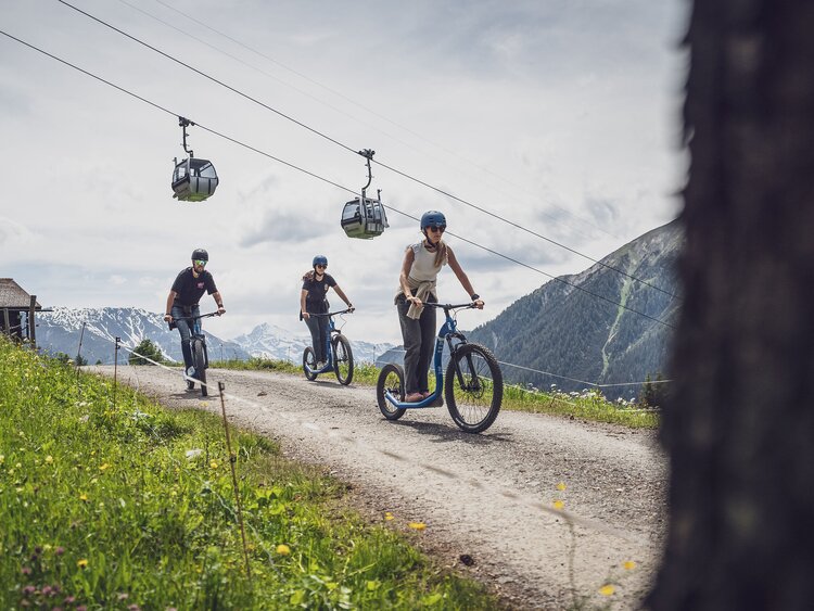 Trottinettfaher unterhalb der Gondelbahn am Rinerhorn in Davos. | © Davos Klosters Mountains