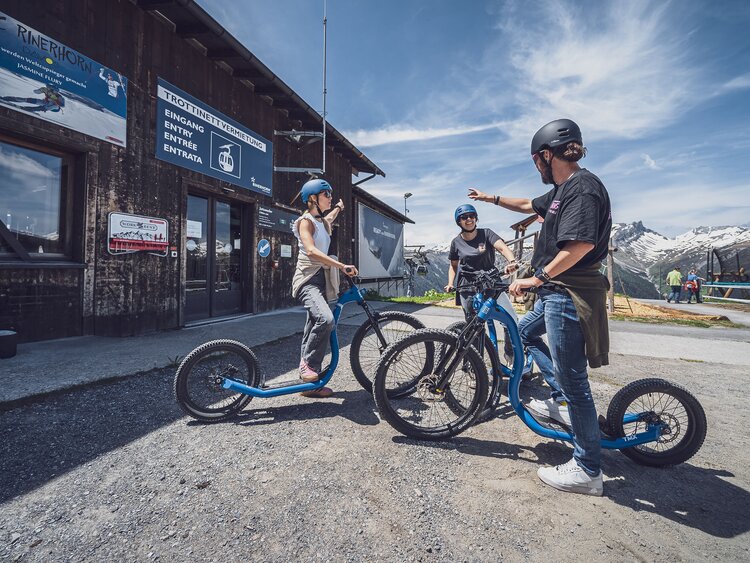 Drei Trottinettfahrer freuen sich auf die Abfahrt am Rinerhorn in Davos. | © Davos Klosters Mountains