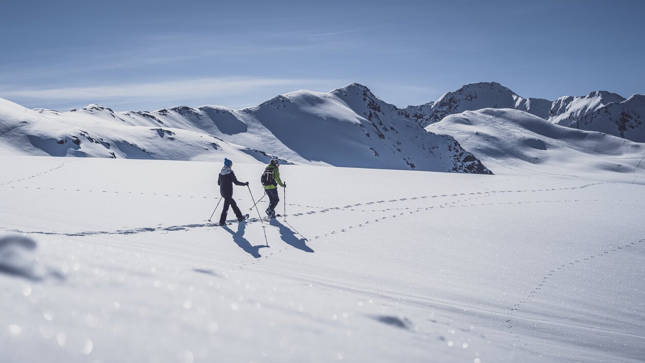 Zwei Frauen laufen mit den Schneeschuhen durch den tiefen Schnee. | © Davos Klosters Mountains
