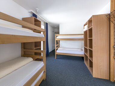Mehrbettzimmer mit Stockbetten und Kleiderablagen | © Davos Klosters Mountains 
