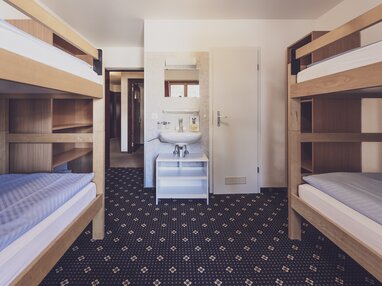 Mehrbettzimmer mit Stockbetten und Waschbecken | © Davos Klosters Mountains