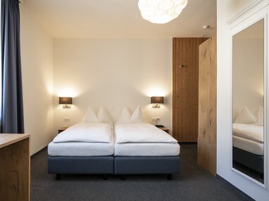 Doppelzimmer mit Spiegel und Tisch | © Davos Klosters Monutains